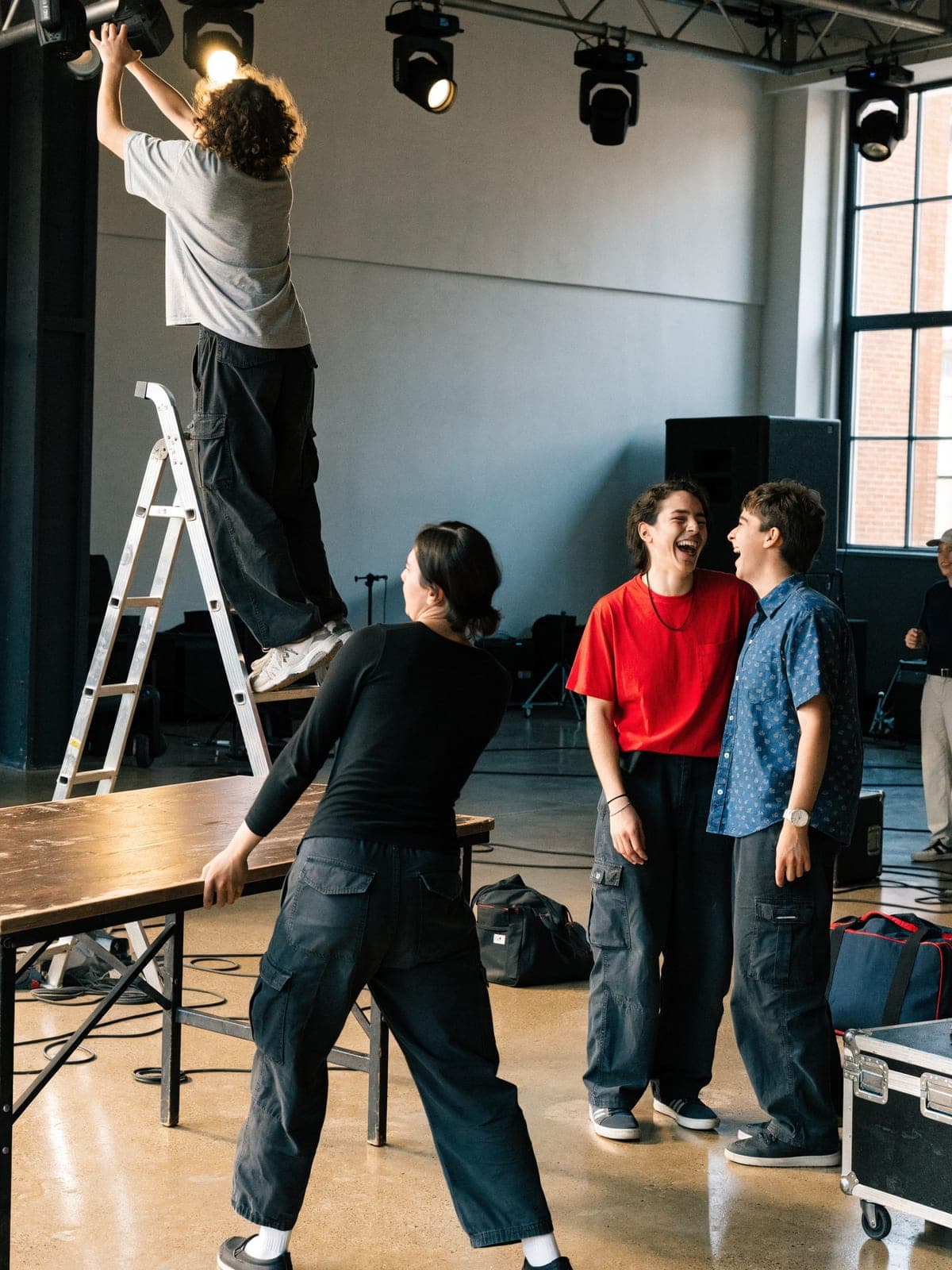 Event crew setting up tables, lighting and chairs in a hall